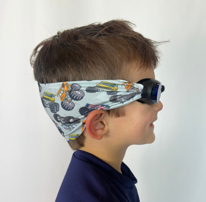 side view of orange and yellow Monster Trucks kids swim goggles with adjustable fabric strap and floatable goggles – Snappy Goggles