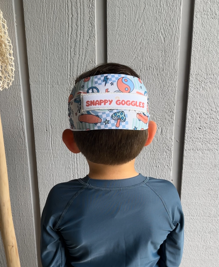 Child wearing a colorful rad vibes fabric strap swim goggle that are floatable - Snappy Goggles
