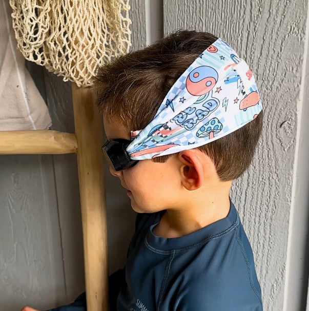 Child wearing a colorful rad vibes fabric swim goggles that don't pull or tangle hair - Snappy Goggles