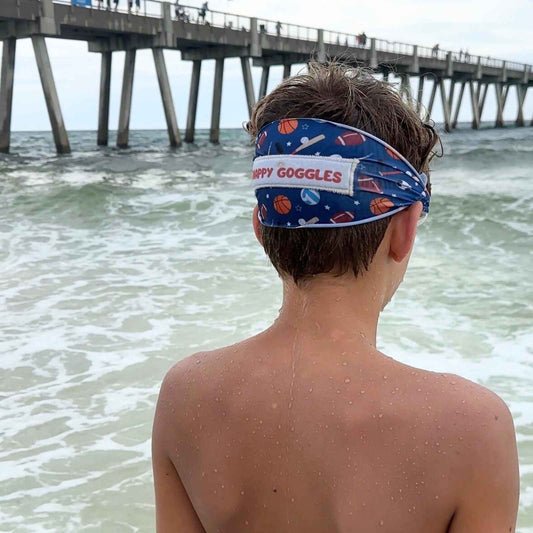 teenager wearing blue all sports kids fabric swim goggles looking into the ocean – Snappy Goggles