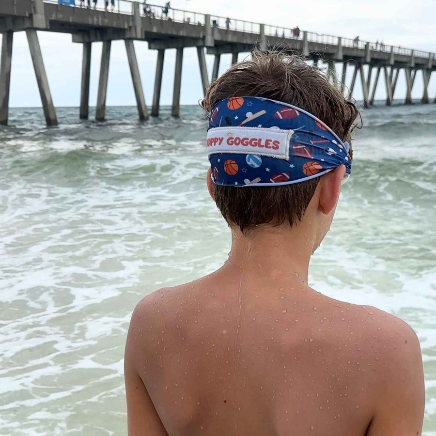 teenager wearing blue all sports kids fabric swim goggles looking into the ocean – Snappy Goggles