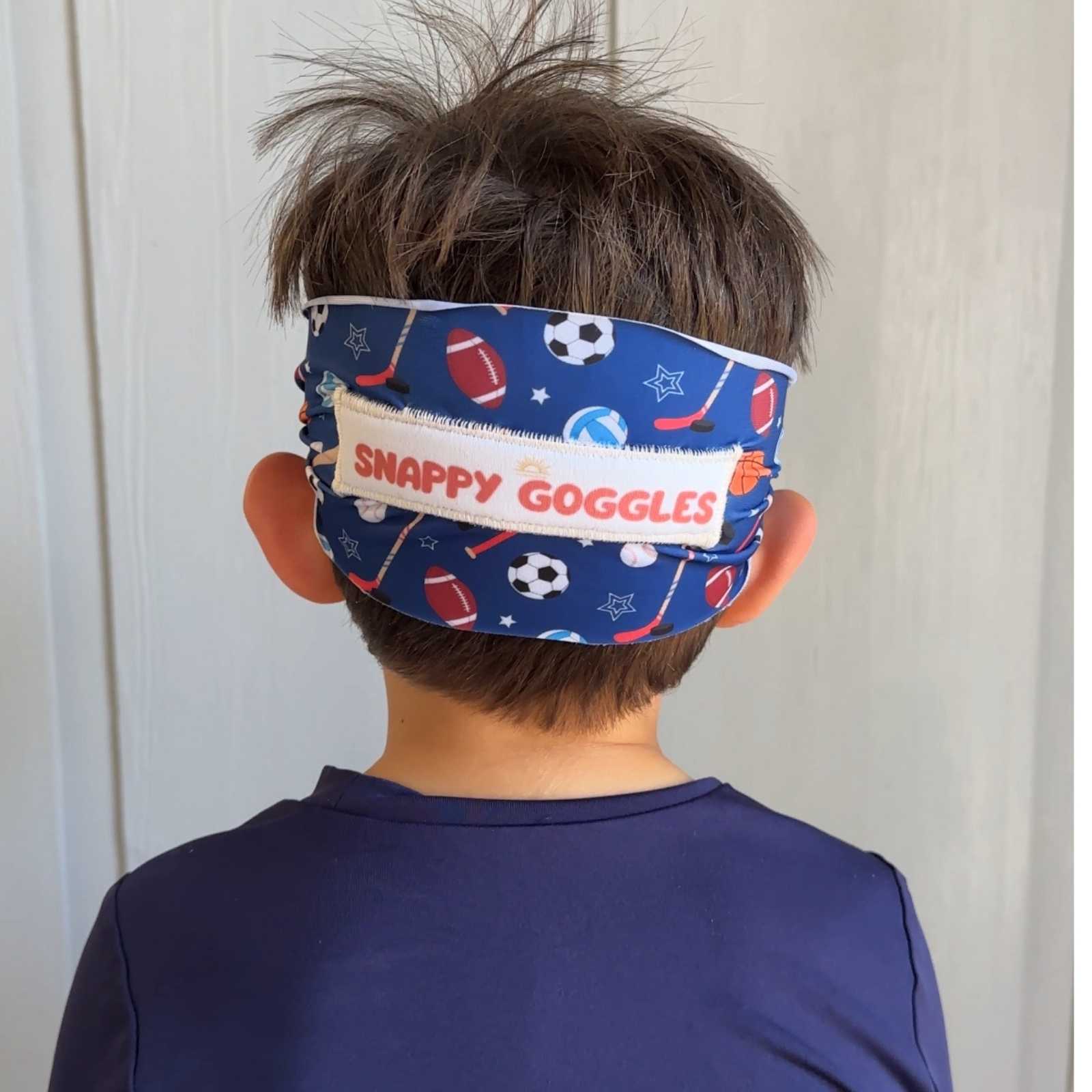 Child wearing a blue sports fabric strap swim goggles 'Snappy Goggles'  branding with floatable goggles