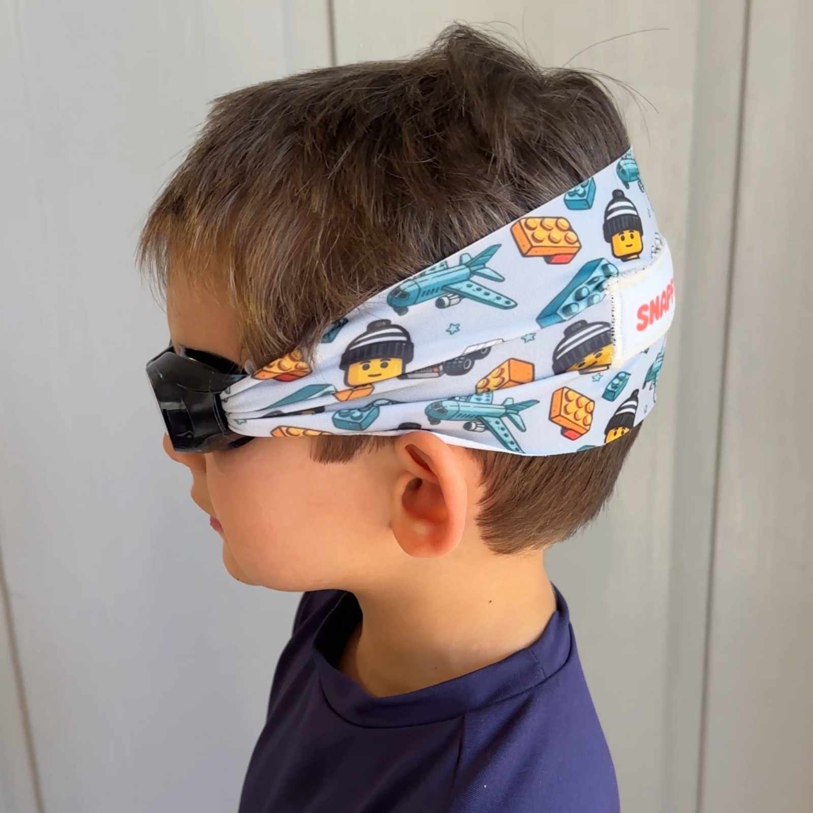 blue Aqua Block kids swim goggles side view with floatable, fabric strap – Snappy Goggles