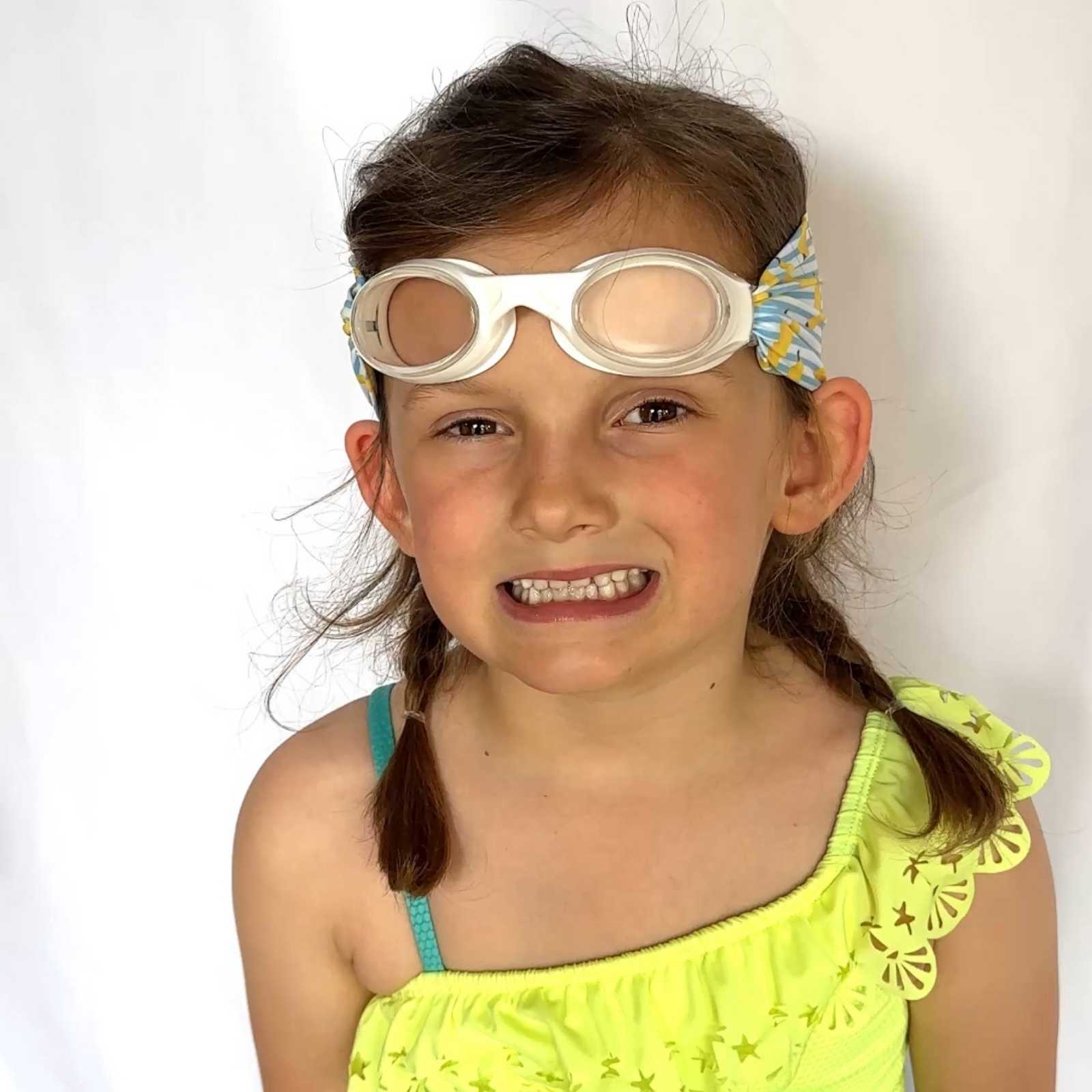 Young girl wearing banana fabric strap swim goggles on top of her head - Snappy Goggles