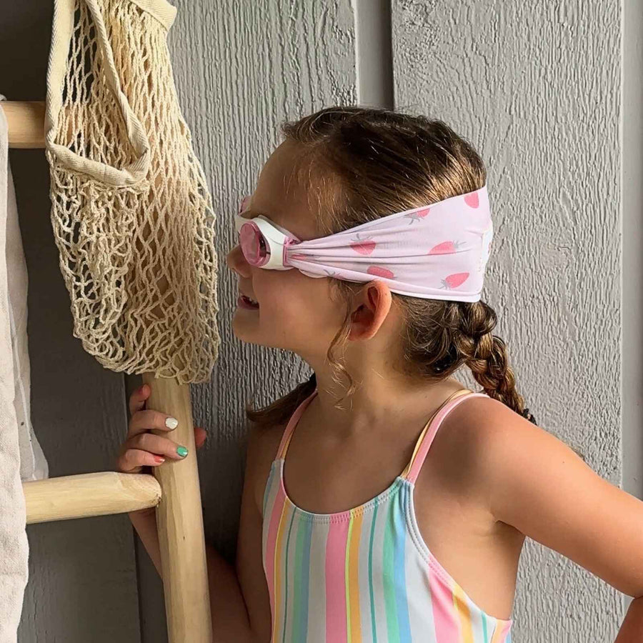 side view of pink strawberry kids swim goggles with adjustable, fabric strap – Snappy Goggles