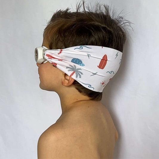 side view of blue and orange palm trees, suns, and surf boards kids swim goggles with adjustable fabric strap and floatable goggles – Snappy Goggles
