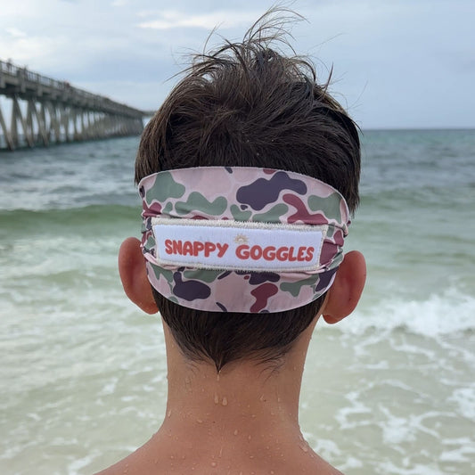 camo kids swim goggles back view with fabric strap on the beach – Snappy Goggles