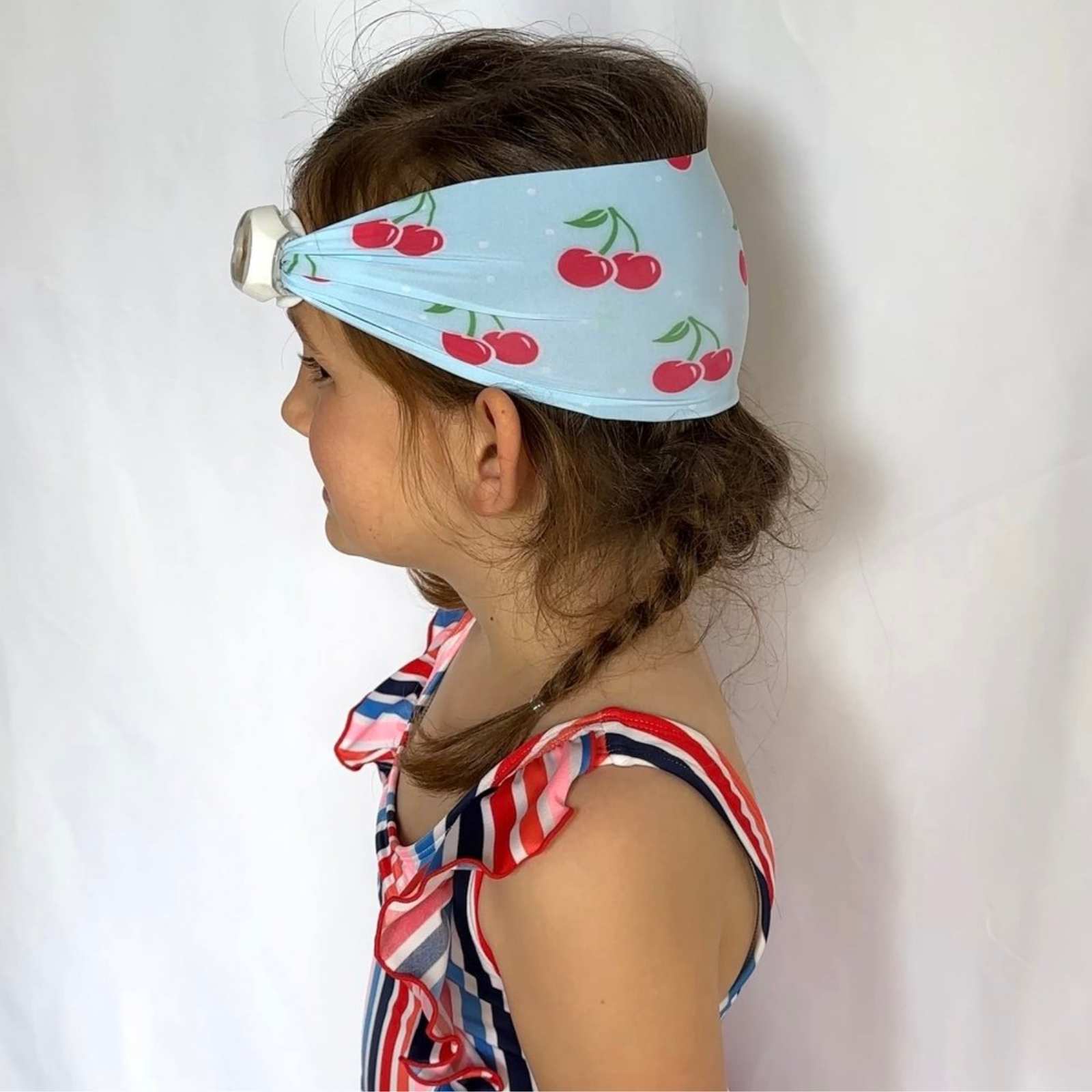 side view of blue and red cherry kids swim goggles with adjustable fabric strap and floatable goggles – Snappy Goggles