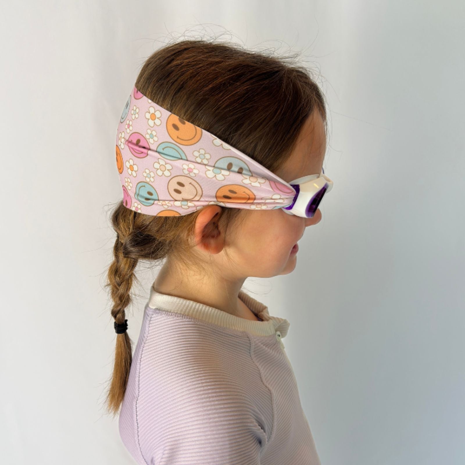 side view of purple organge and blue smiley faces and flowers kids swim goggles with adjustable fabric strap and floatable goggles – Snappy Goggles
