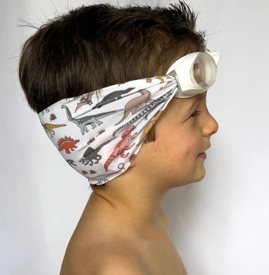 side view of orange yellow and green dinosaurs kids swim goggles with adjustable fabric strap and floatable goggles – Snappy Goggles