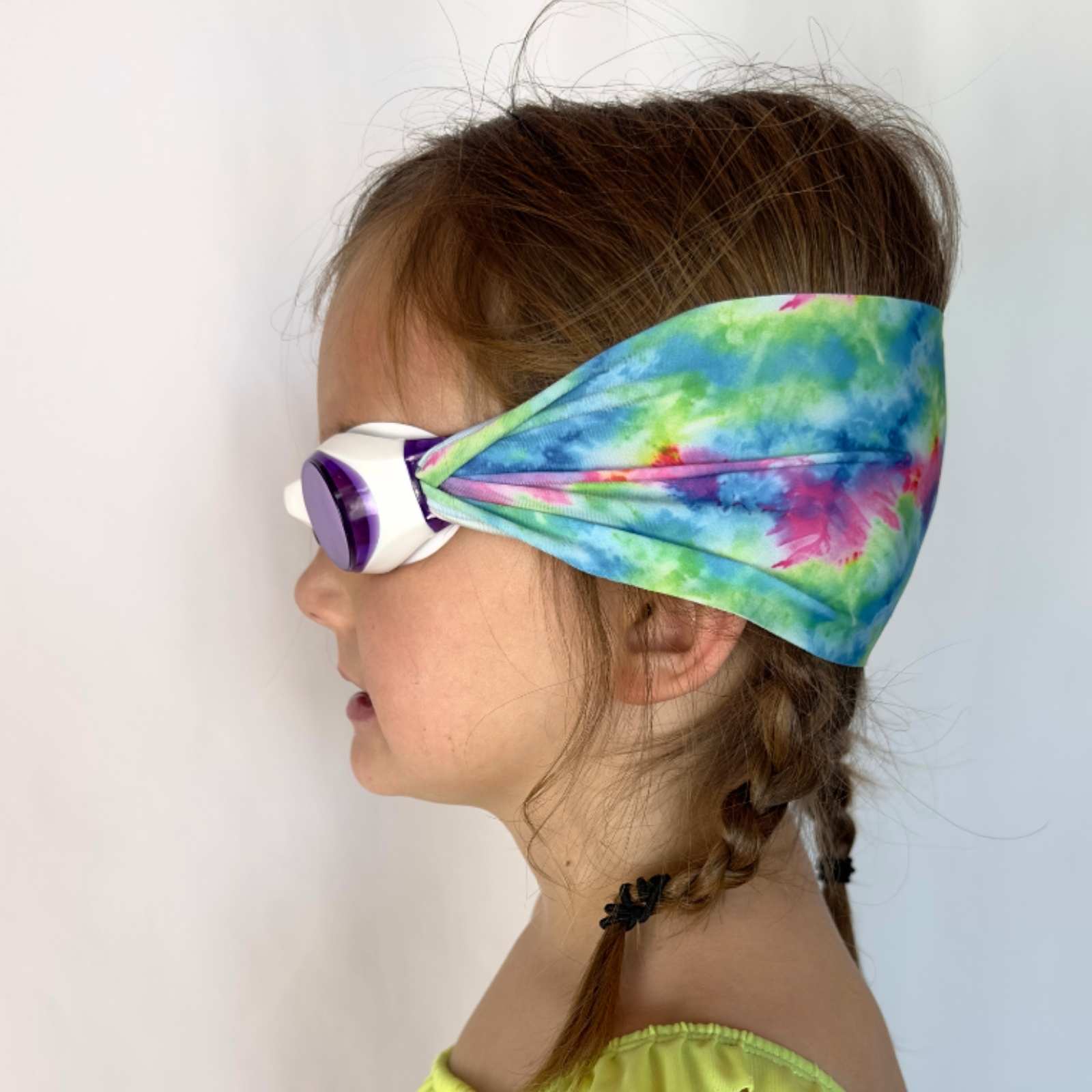 side view of pink purple blue green tie dye kids swim goggles with adjustable fabric strap and floatable goggles – Snappy Goggles