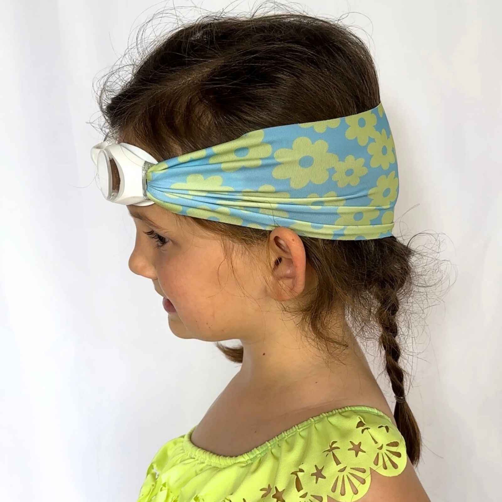 side view of blue and green flower kids swim goggles with adjustable fabric strap and floatable goggles – Snappy Goggles