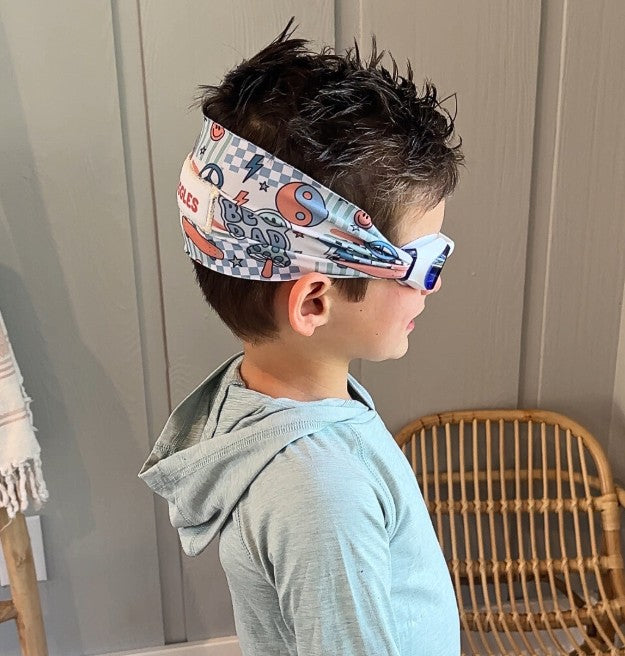 side view of blue and orange ying yangs, mushrooms, peace signs, smiley faces kids swim goggles with adjustable fabric strap and floatable goggles – Snappy Goggles