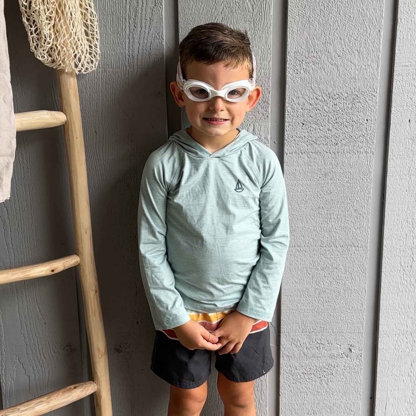 Child wearing fabric swim goggles that don't pul hair and float - Snappy Goggles